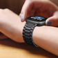 Closeup of Model’s Wrist, Wearing a Black Link Style Bracelet Band and Fitbit Versa.