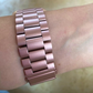 Closeup of Model’s Wrist, Wearing a Pink Link Style Bracelet Band and Fitbit Versa.