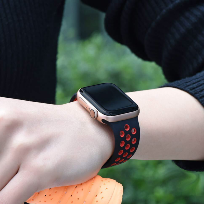 Closeup of Model's Wrist, Wearing a Black and Red Nike Style Sport Band and Apple Watch.