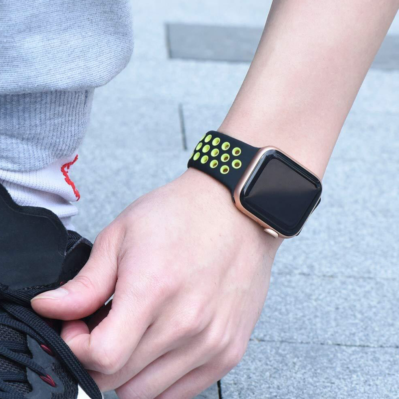 Closeup of Model's Wrist, Wearing a Black and Volt Neon Yellow Green Nike Style Sport Band and Apple Watch.