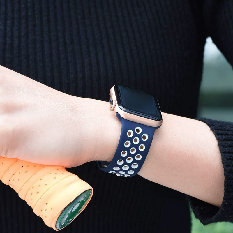 Closeup of Model's Wrist, Wearing a Navy Blue and White Nike Style Sport Band and Apple Watch.