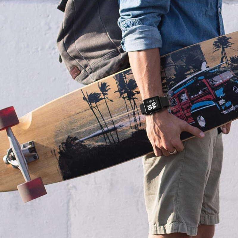 Male Model Holding Skateboard and Wearing a Black Silicone Sport Strap and Apple Watch.