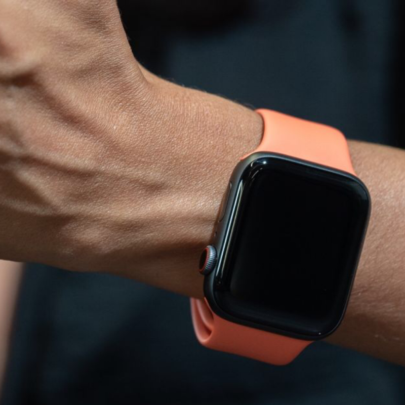 Closeup of Model’s Wrist, Wearing a Papaya Orange Silicone Sport Strap and Apple Watch.