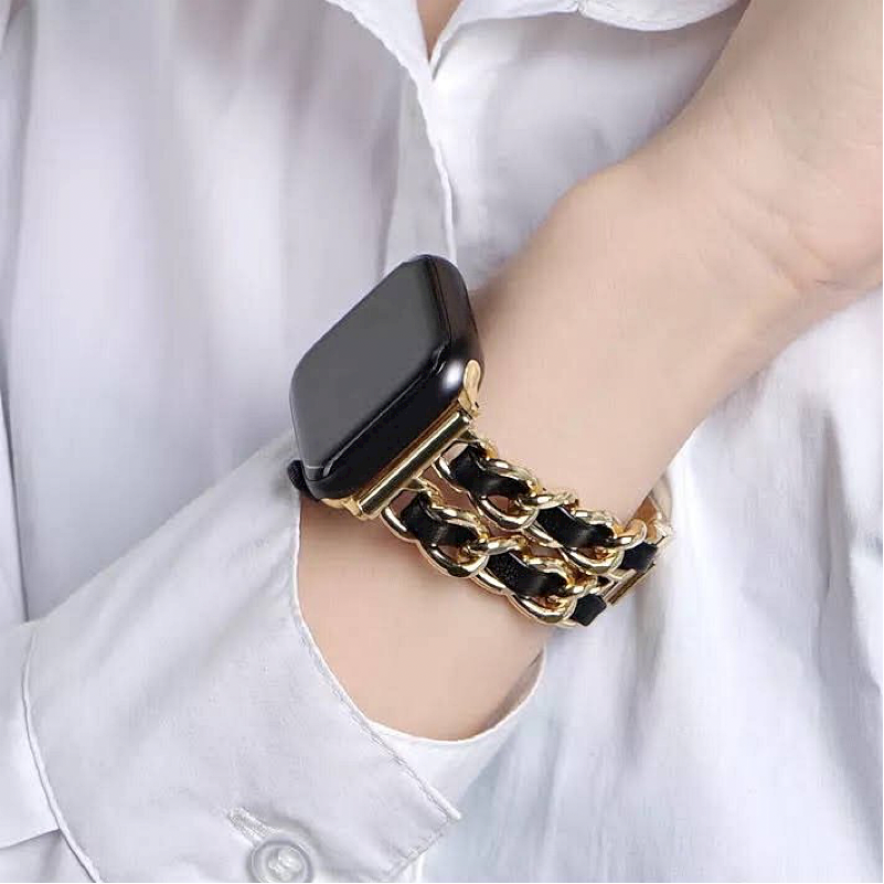 Closeup of Model's Wrist, Wearing a Gold and Black Leather Chain Bracelet Band on a Space Gray Apple Watch.