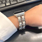 Closeup of Model's Wrist, Wearing a Silver and White Leather Chain Bracelet Band on an Apple Watch.